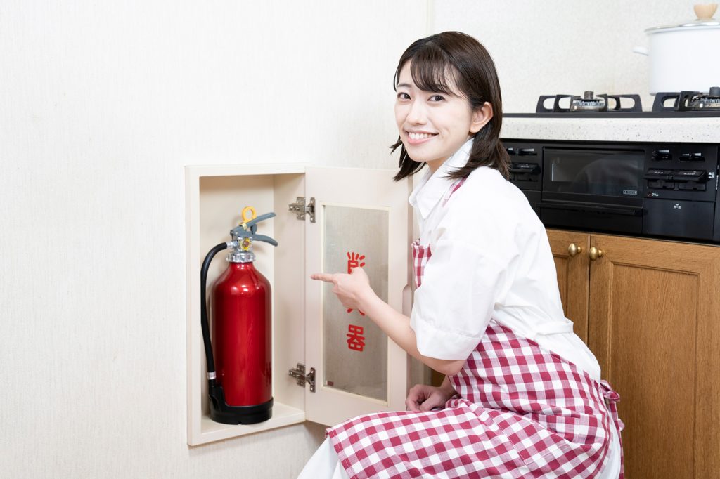 給湯器を指さす女性